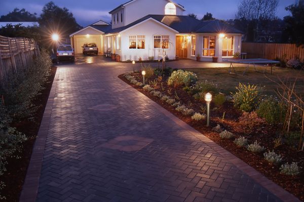 New home at night with brick paver driveway in herringbone pattern